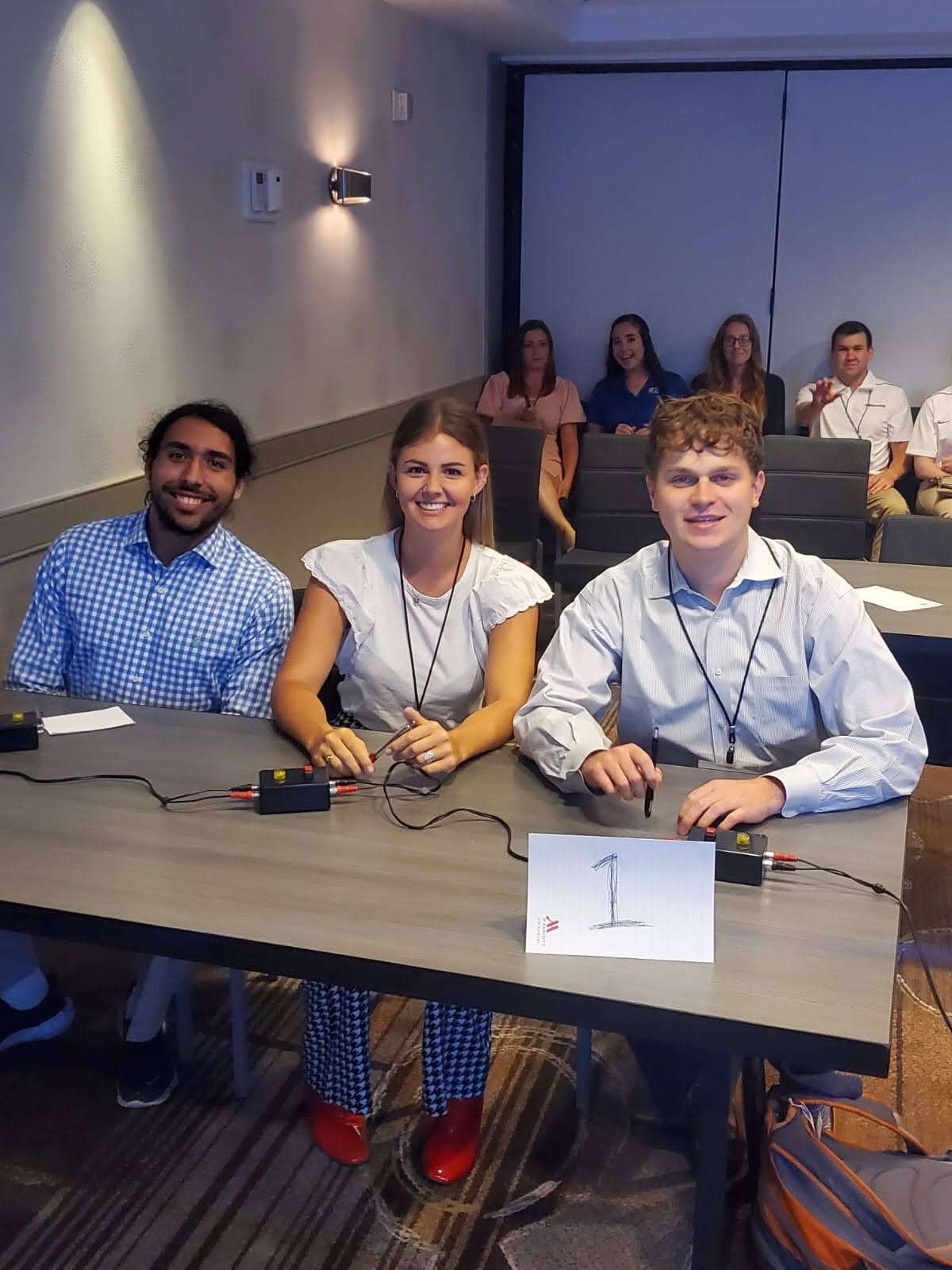 Quiz bowl team one sit at table before competition