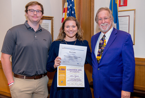 CAEP graduate Kira Yeates holds her completion certificate in this photo taken at the program's graduation ceremony. She stands beside program director Brian Andrews.