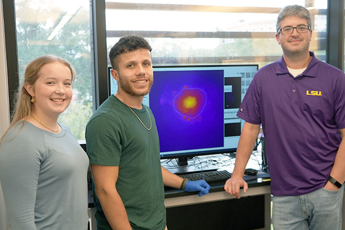 Adam Melvin and students in front of computer