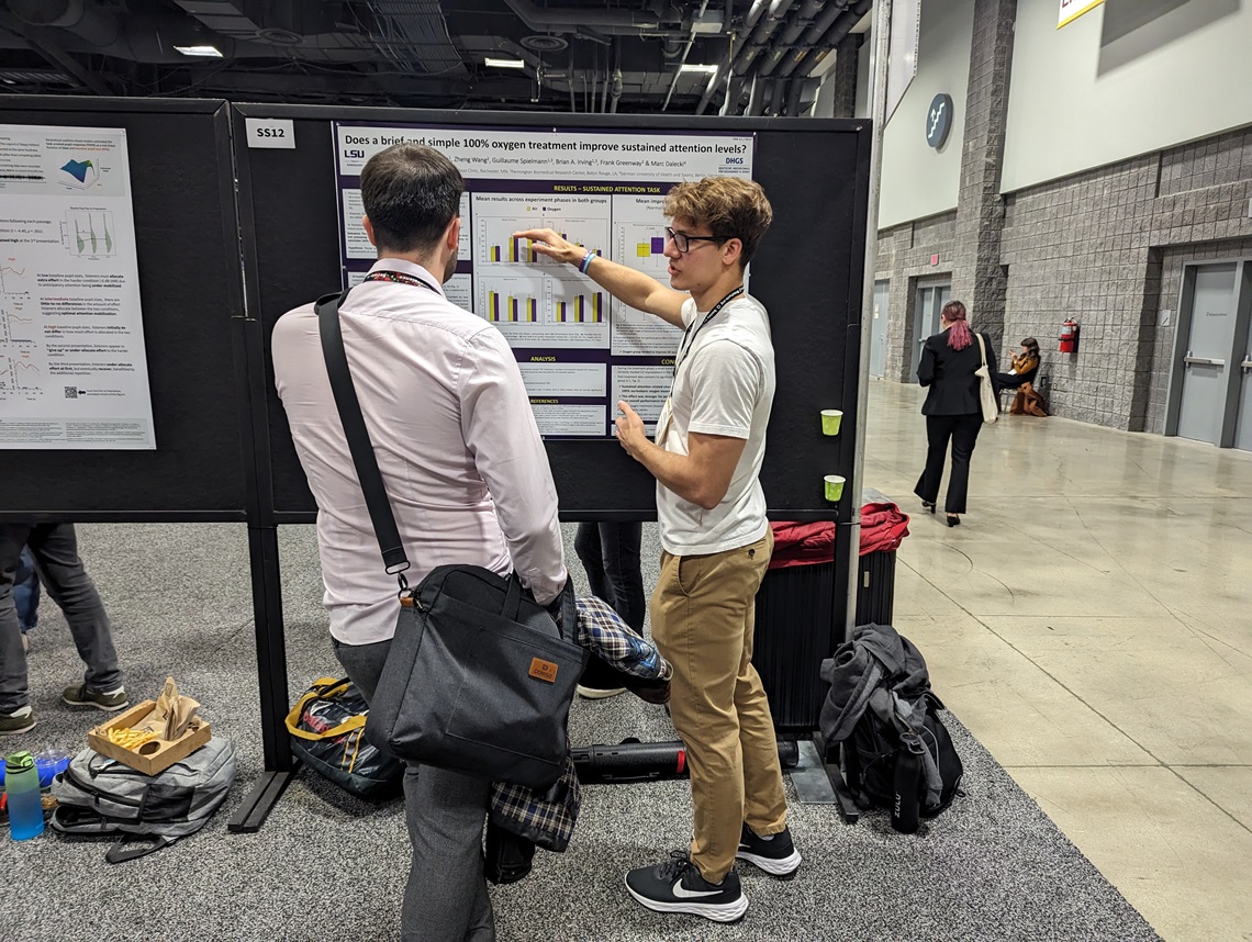 Student presenting a research poster at a conference