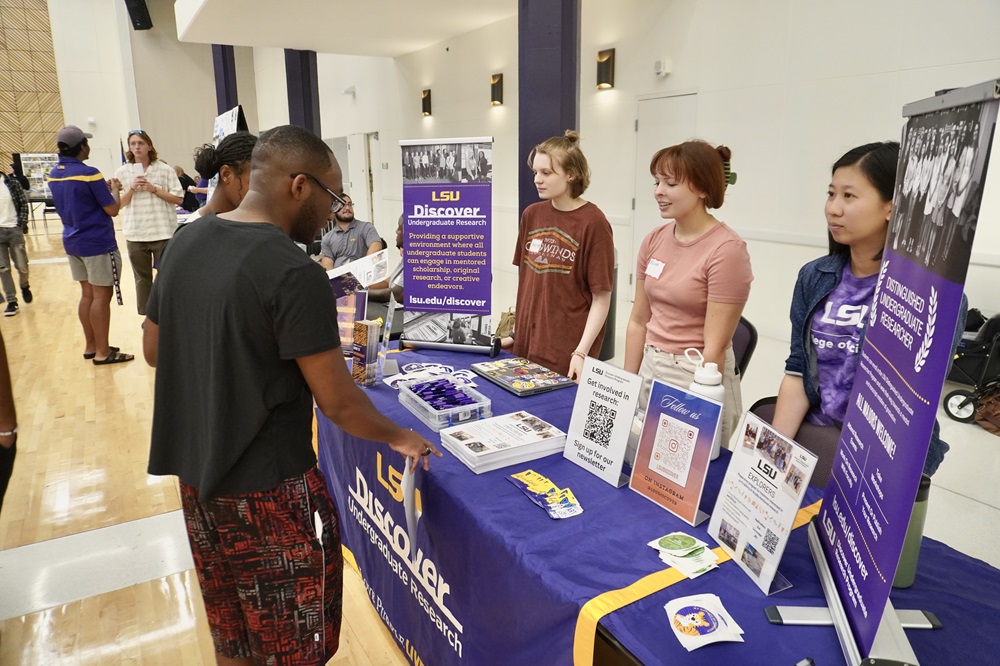 Three students providing information at a campus event